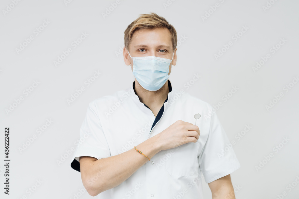 Portrait of a young male dentist wear sterile mask isolated on white background