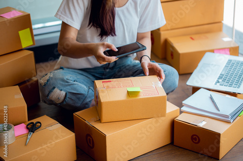 Portrait of Starting small businesses SME owners female entrepreneurs working, box and check online orders to prepare to pack the boxes, sell to customers, sme business ideas online.