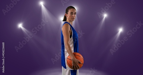 Composition of caucasian male basketball player holding ball with spot lights and copy space