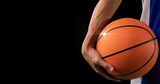 Composition of midsection of male basketball player with ball and copy space on black background