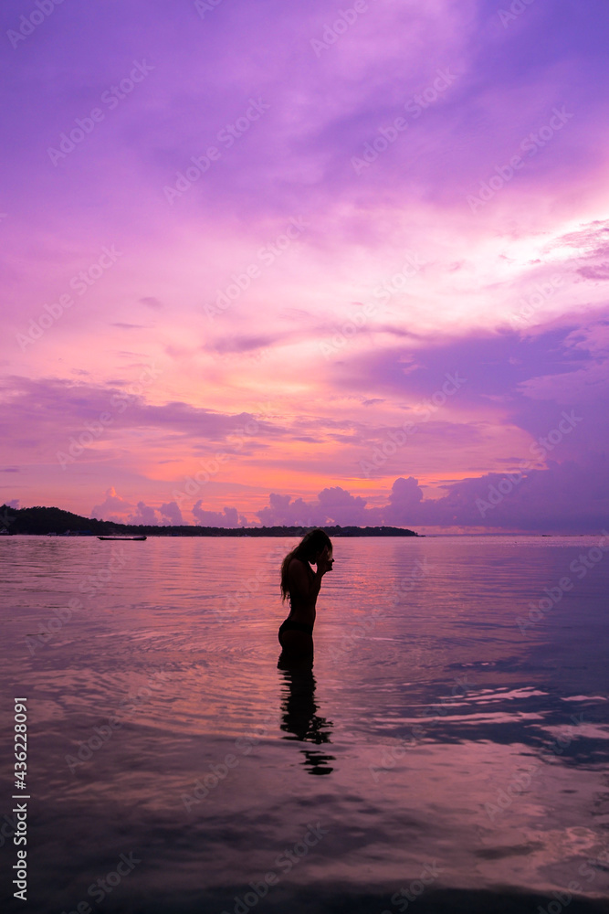 Fototapeta premium Woman silhouette at sunset on vacation