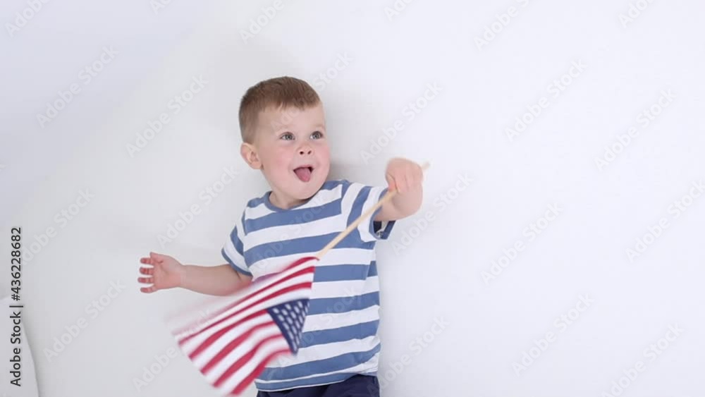 little child boy in blue striped t-shirt waving American flag and smiling. usa Independence Day concept. little child boy in blue striped t-shirt waving American flag and smiling. usa Independence Day concept.