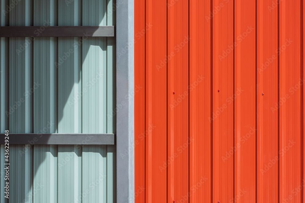 Sunlight and shadow on steel wall surface of storage room or garage with orange metal sheet fence wall outside of home, construction material concept Sunlight and shadow on steel wall surface of storage room or garage with orange metal sheet fence wall outside of home, construction material concept