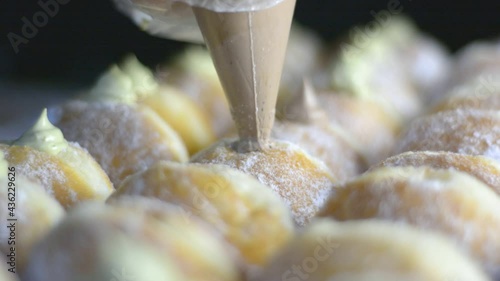 filling the bomboloni doughnut with vanila cream