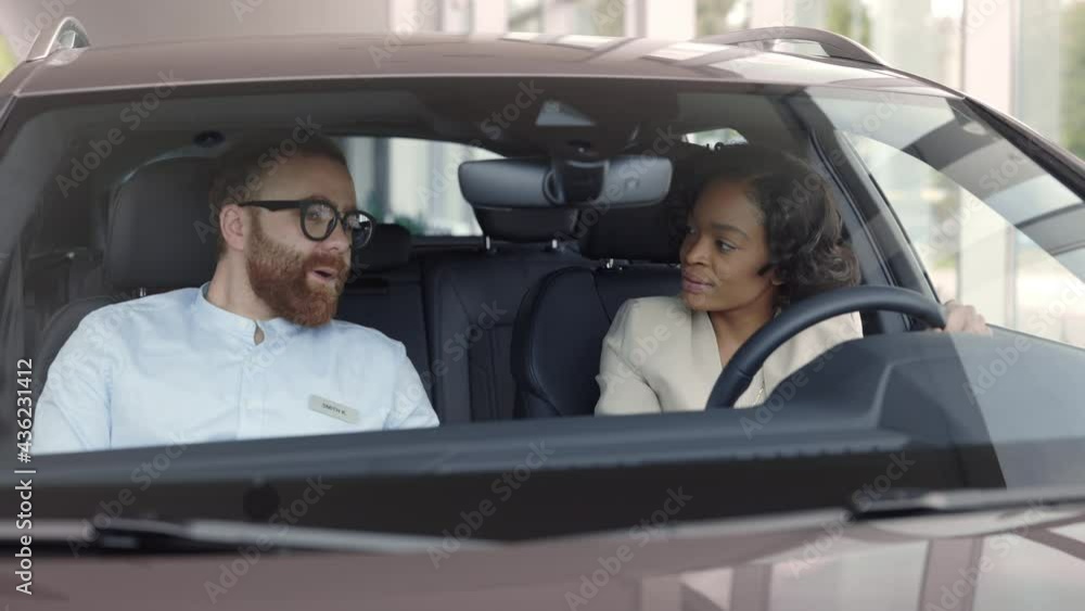 Salesman presenting new car to female customer Salesman presenting new car to female customer