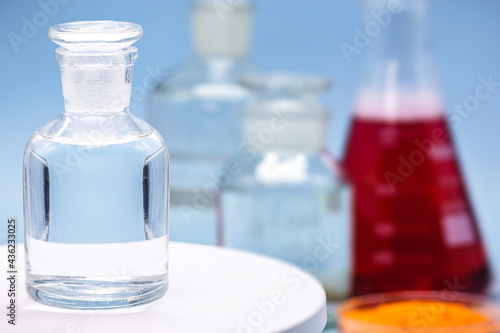 Konstfotografi Reagent bottle with glass stopper, blue background, pharmacy or medicine concept