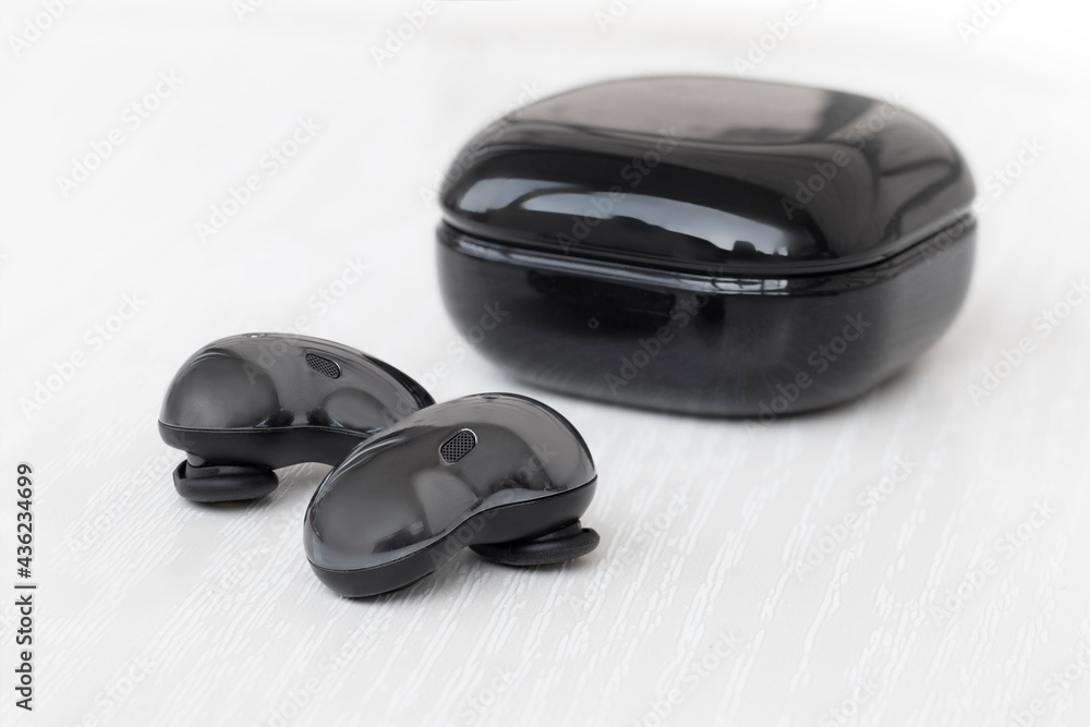 Wireless headphones in a case
on a light wood background Wireless headphones in a case
on a light wood background