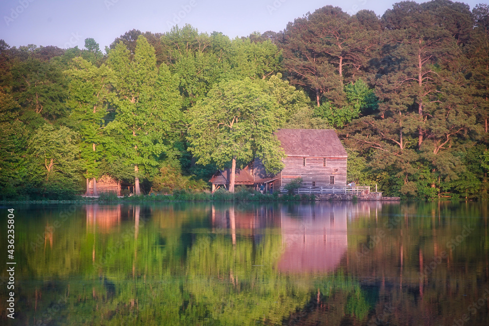 A beautiful view in Spring of Yates Mill Pond in North Carolina with trees reflecting in the water.