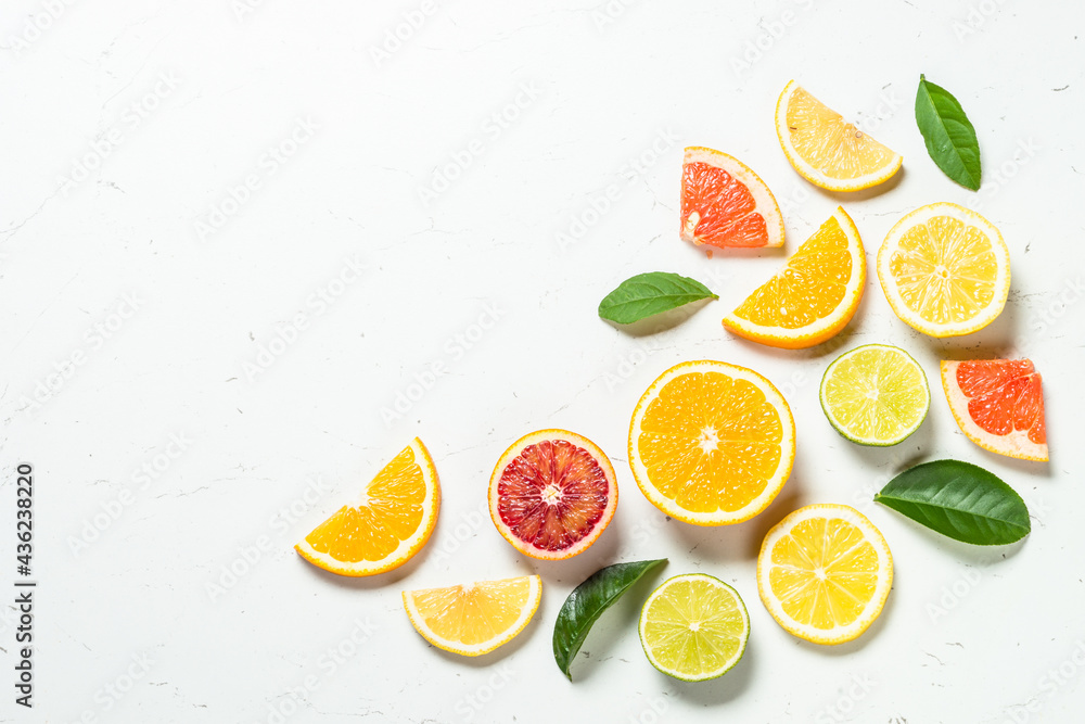 Citrus fruits at white background. Orange, lemon, lime, grapefruit with green leaves. Healthy food. Top view with copy space. Citrus fruits at white background. Orange, lemon, lime, grapefruit with green leaves. Healthy food. Top view with copy space.