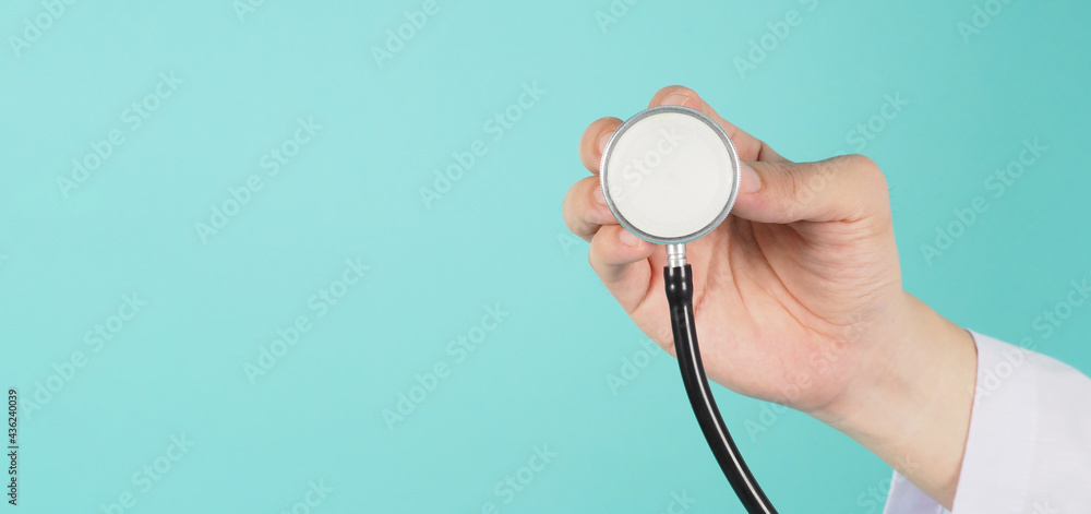 close up of doctor hand holding stethoscope and wear long sleeve gown on mint green or tiffany blue background close up of doctor hand holding stethoscope and wear long sleeve gown on mint green or tiffany blue background