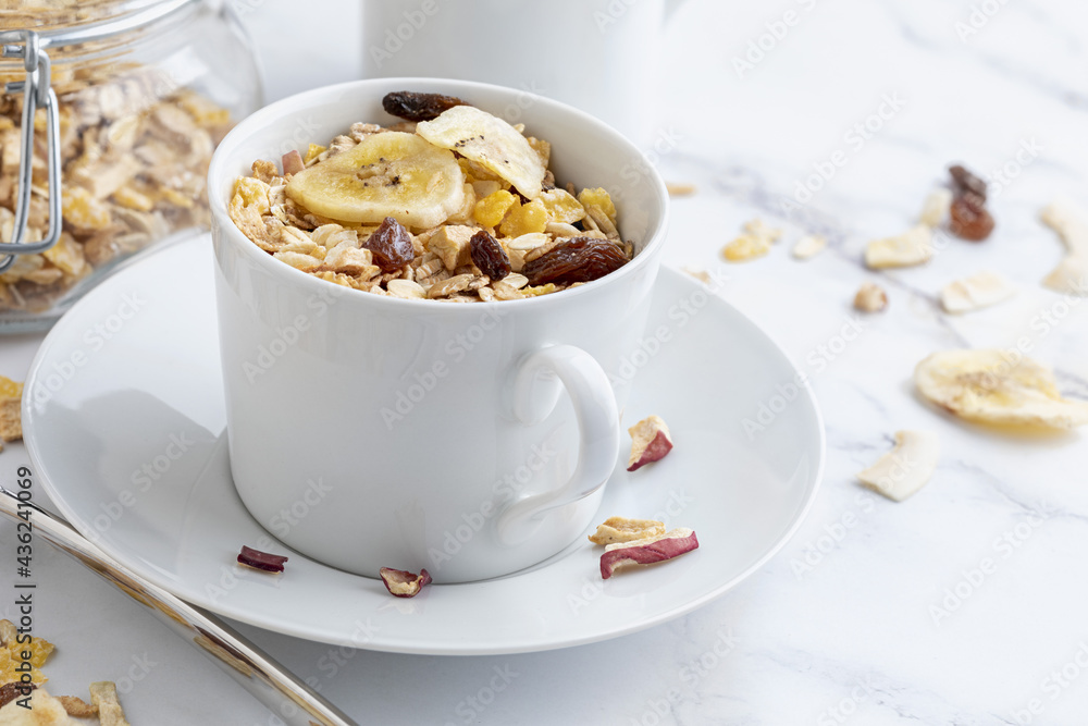 Bowl of milk with whole grains for breakfast. Muesli with dried fruits and dried fruits. With copy space. On light background. Bowl of milk with whole grains for breakfast. Muesli with dried fruits and dried fruits. With copy space. On light background.