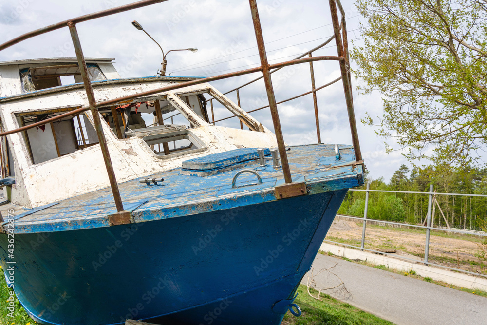 abandoned wrecked boat lying on the shore, waiting for repairs, fishing boat