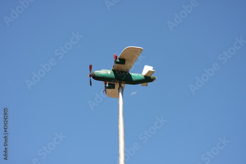turquoise wooden airplane in the blue sky