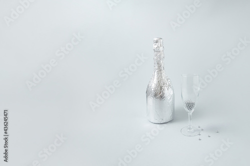 Silver champagne and glass on monochromatic background. Party card. © Elizia Jovanovic