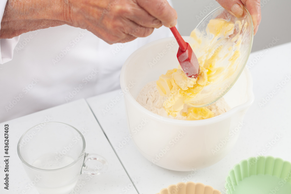 Senior woman preparing dough for a delicious cheese and ham tartlet Senior woman preparing dough for a delicious cheese and ham tartlet