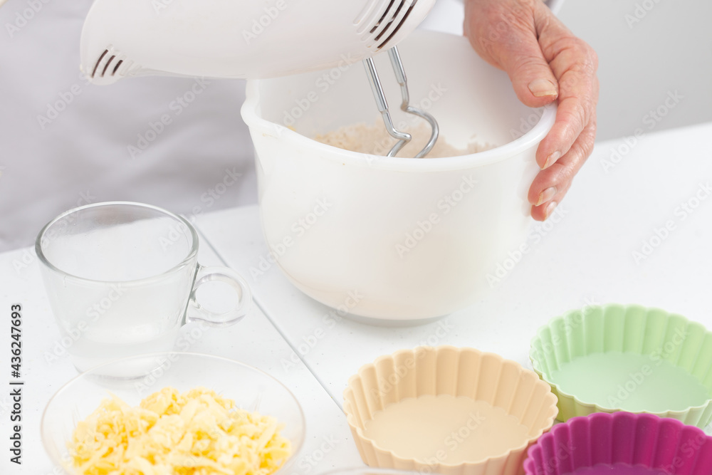 Senior woman preparing dough for a delicious cheese and ham tartlet Senior woman preparing dough for a delicious cheese and ham tartlet