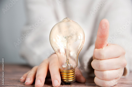 Shining lightbulb with thumbs up, Good Idea and brainstorming, creative business or education concept background modern style photo