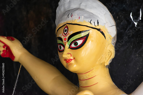 Clay idol of Goddess Devi Durga is in preparation for the upcoming Durga Puja festival at a pottery studio in Kolkata, West Bengal, India. Close Up. Selective focus. photo