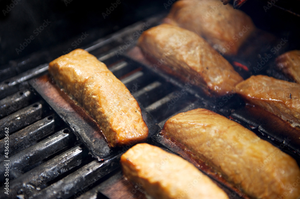 Φωτογραφία Salmon grilling on a BBQ with a cedar plank.