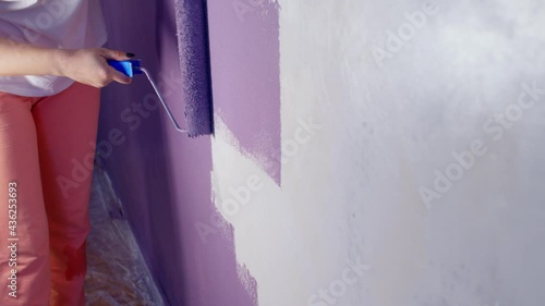 Wallpaper Mural Close up of woman's hand in protective glove painting wall in purple colour with roller. Unrecognizable person applying paint on wall. Concept of repair work and improvement of housing conditions Torontodigital.ca