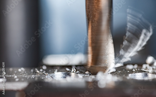 Drilling process with shavings close-up at the workplace in workshop
