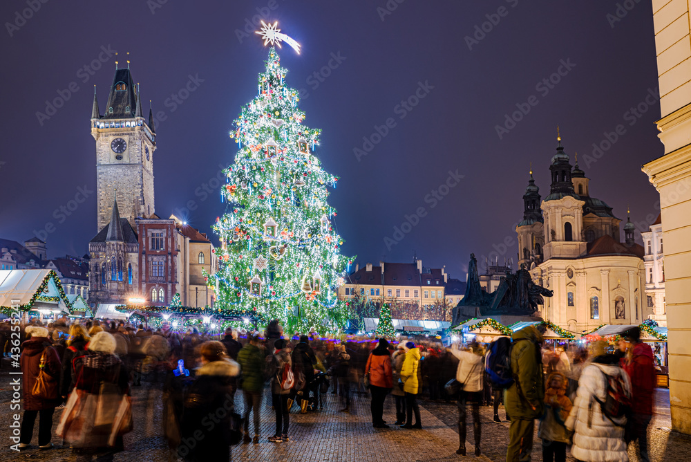 People celebrating Christmas religious holiday outdoors into the downtown of Prague among the tree and lights decoration in winter season