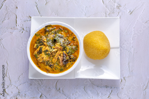 Oha / Ora Soup served in a ceramic bowl with garri photo