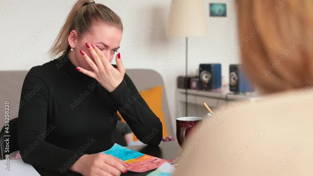 A woman cries during psychotherapy, she wipes her eyes with her hands. Emotion relaxation, mental clamping. Restoration of mental health. A woman cries during psychotherapy, she wipes her eyes with her hands. Emotion relaxation, mental clamping. Restoration of mental health.