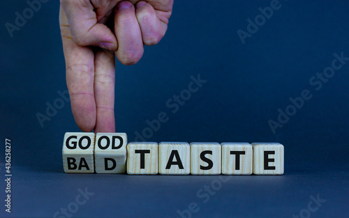 Good or bad taste symbol. Businessman turns wooden cubes and changes words 'bad taste' to 'good taste'. Beautiful grey table, grey background, copy space. Business and good or bad taste concept.