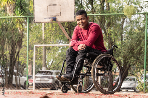 portrait of wheelchair man in open basketball court..