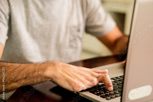 Fotografija male fingers amputee typing in laptop.