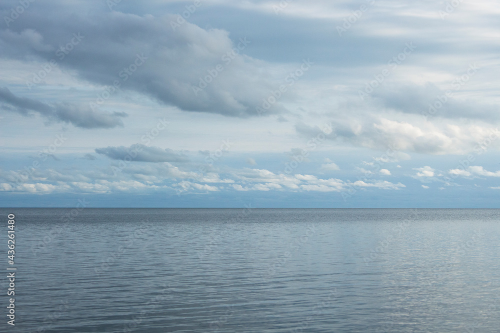 Panoramic view of blue sea and clear sky with white clouds.Nature,climate change,reflections of symmetry on water in daylight.The idea of ​​feeling calm and relaxing for the background and copy space.