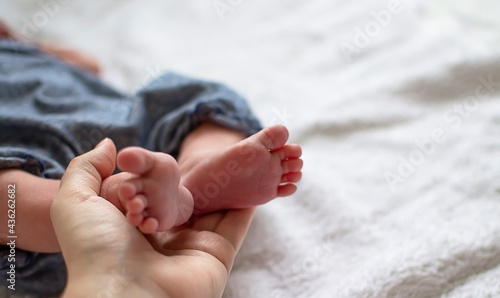 Baby feet in parental hands. Mother and her child. Feet of a newborn. Happy family and motherhood concept. © Татьяна Качайло