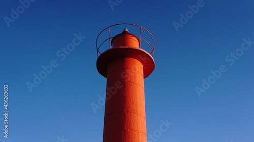 red lighthouse tower against blue sky