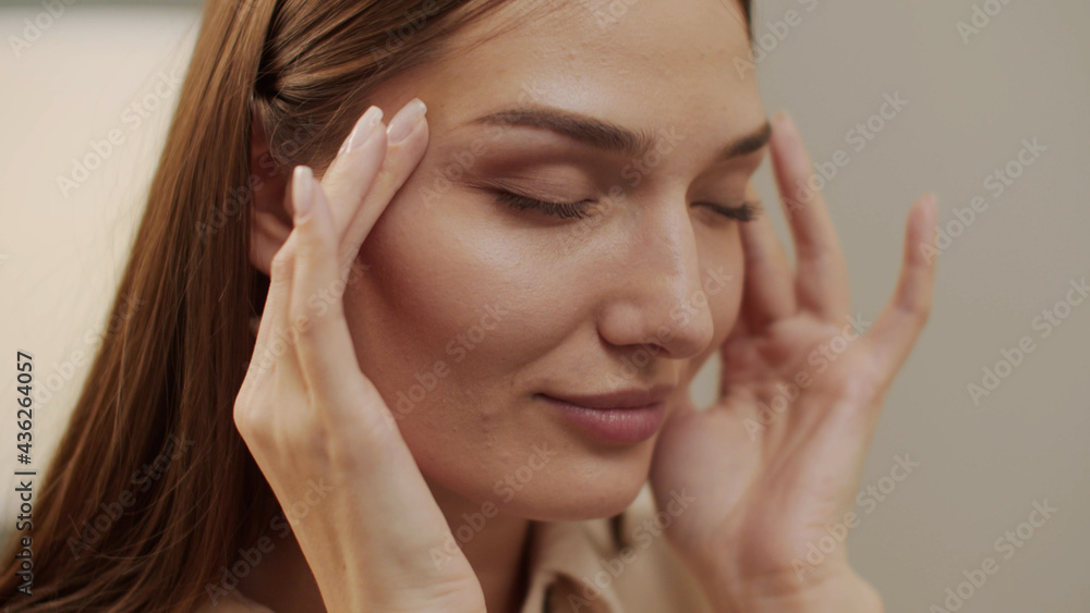 Tired beautiful woman looking away takes off her glasses and massages her temples Tired beautiful woman looking away takes off her glasses and massages her temples