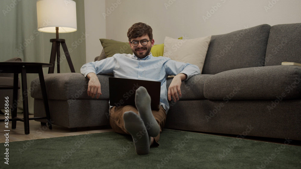 A white man communicates by video link while sitting on the floor A white man communicates by video link while sitting on the floor