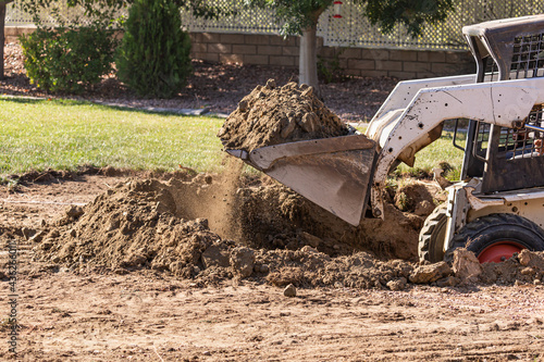 Small Bulldozer Digging In Yard For Pool Installation photo