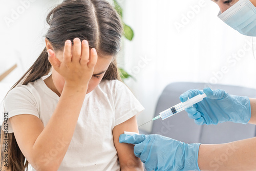 Little girl getting vaccination from pediatrician at medical office