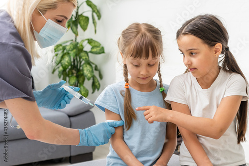 nurse giving vaccination injection to little girl patient