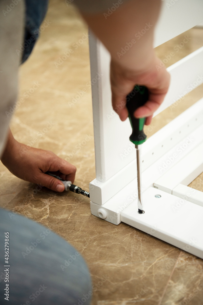 Woman assembling a baby crib.