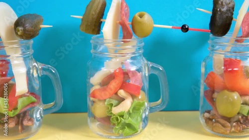 Jarcuterie Snacks in transparent jars cheese ham olives lettuce cucumbers nuts. photo