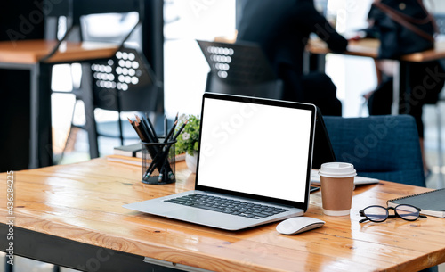 Wallpaper Mural Mockup blank screen laptop computer on wooden table in co-workspace. Torontodigital.ca