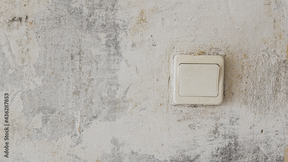Old electric switch on concrete wall with peeling paint Old electric switch on concrete wall with peeling paint