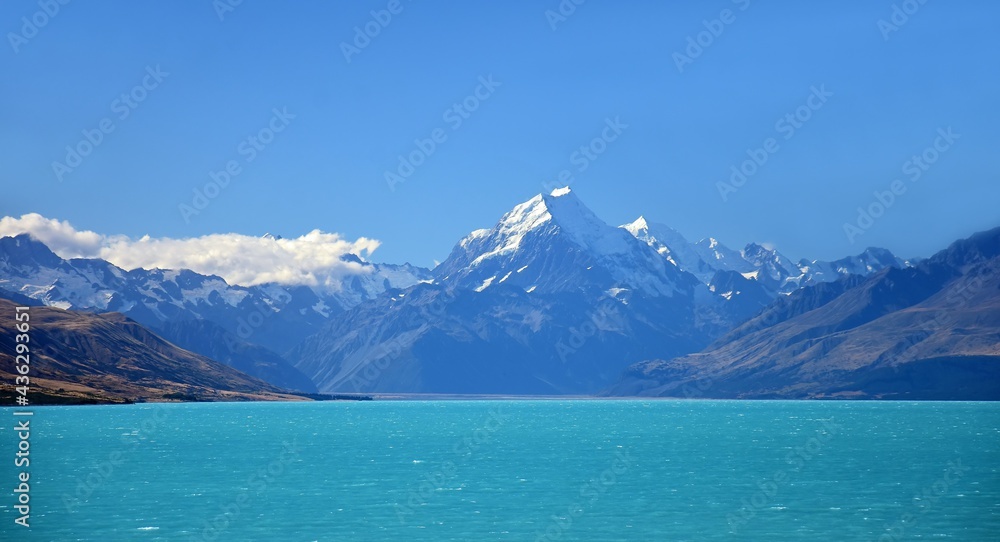 a spectacular view of snow-covered mount cook in the southern alps on a sunny summer day,  across the turquoise-colored waters of lake tekapo ,near twizel, on the south island of new zealand