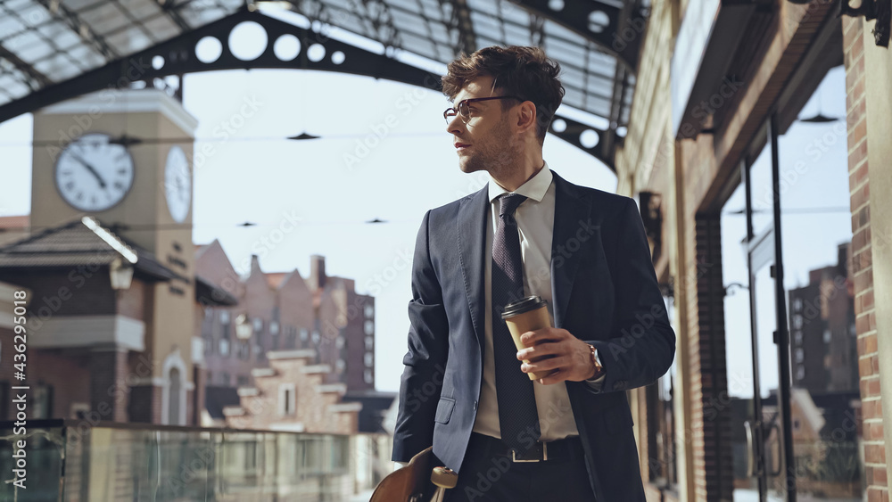businessman holding coffee to go and walking with penny board in shopping  mall. Stock Photo | Adobe Stock