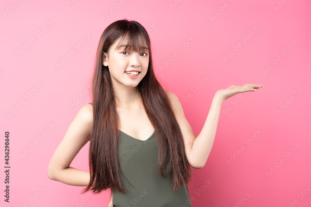 Portrait of a beautiful young asian girl posing on a pink background Portrait of a beautiful young asian girl posing on a pink background
