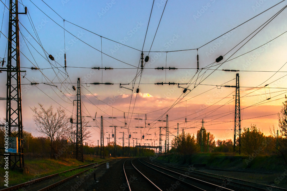 Railway at sunset with railway overhead lines and railway tracks Railway at sunset with railway overhead lines and railway tracks