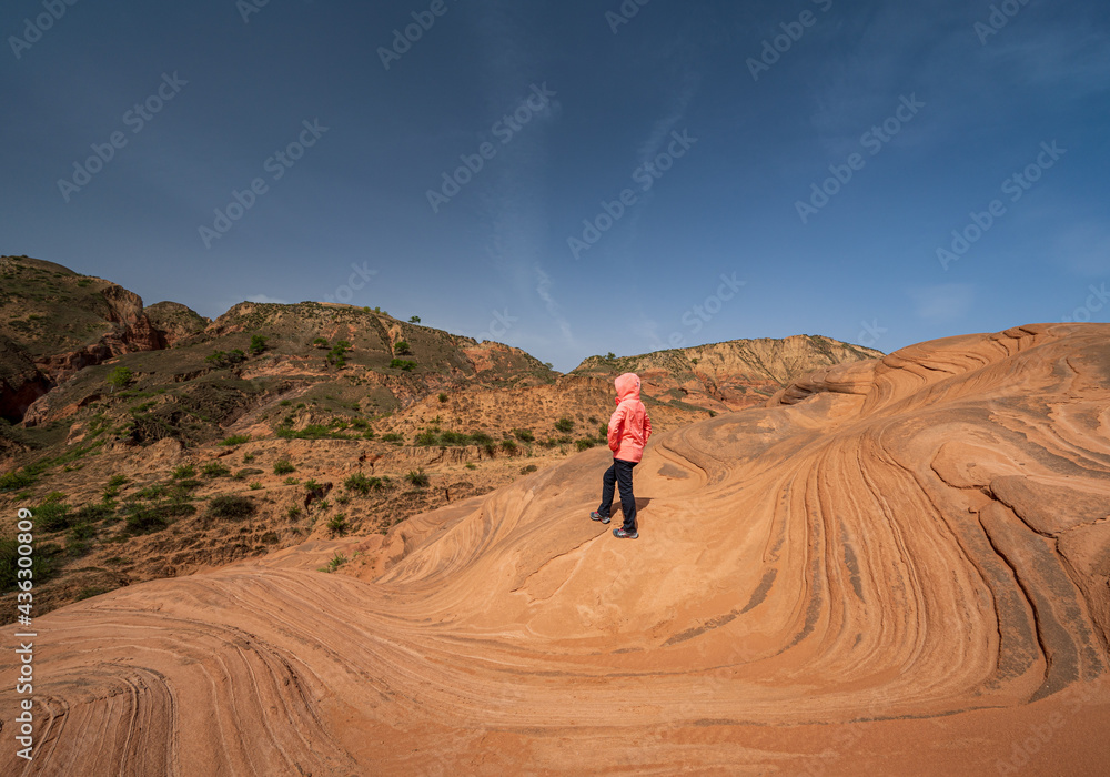 A woman stand on the wave landform rocks