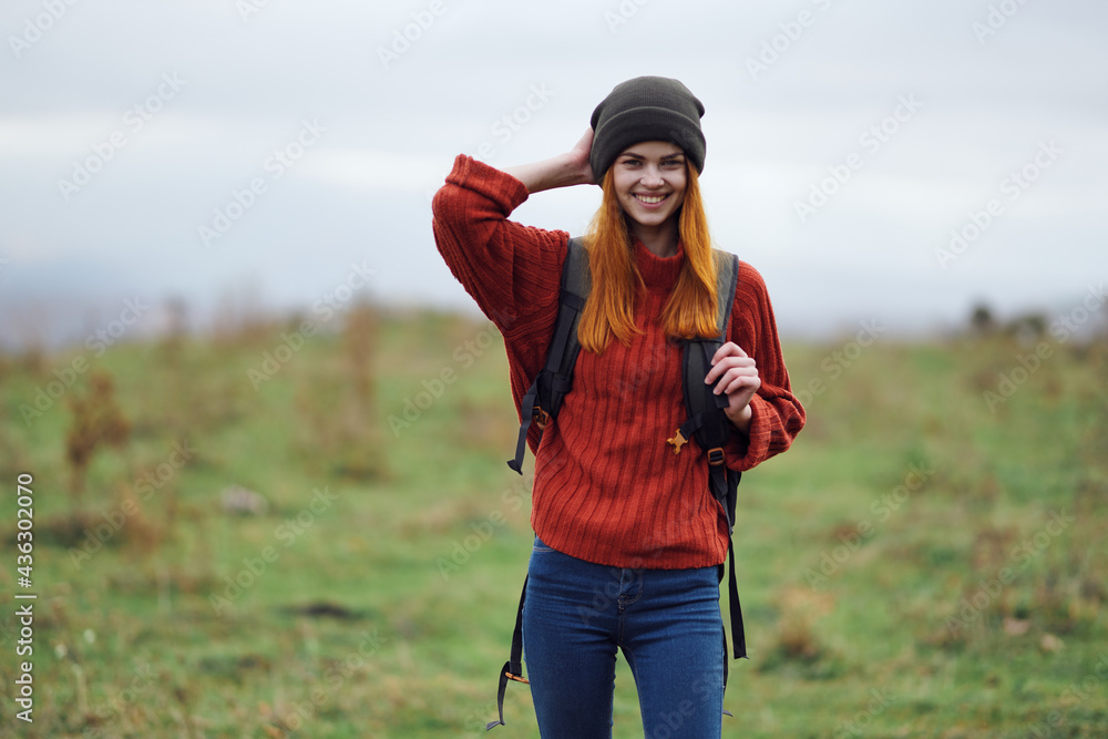 Fototapeta premium cheerful woman hiker in autumn clothes with a cutter in the mountains landscape on a trip
