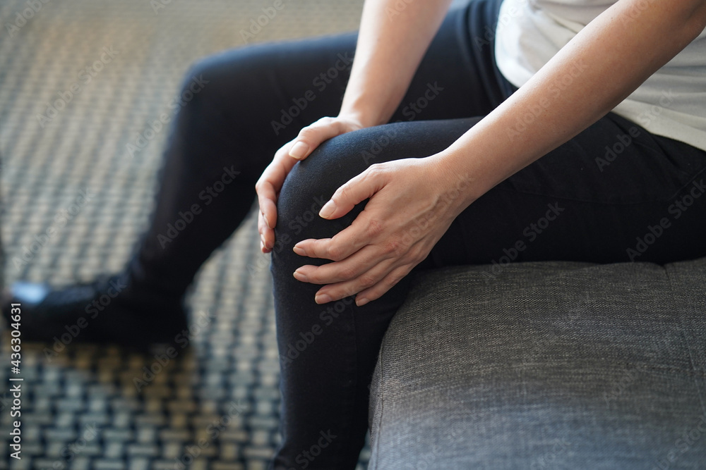 Female hand on Leg With Painful Knees. Woman Feeling Joint Pain, Having Health Issues And Touching Leg With Hands. Pain In Knee. Body And Health Care Concept